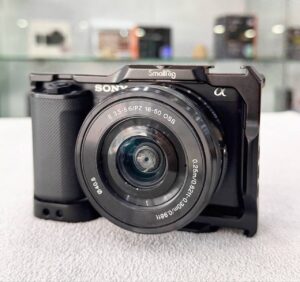 Sony ZV-E10L vlogging camera with 16-50mm power zoom lens, microphone, and SmallRig cage – excellent condition
